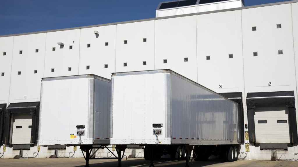 Drop trailers docked at a warehouse shipping facility.