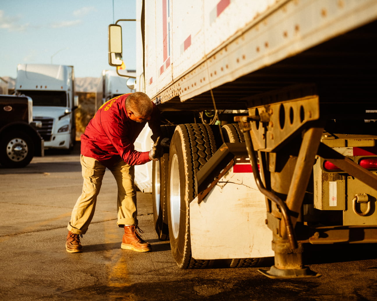 Broker-carrier-safety trucker fixing tire on semi truck